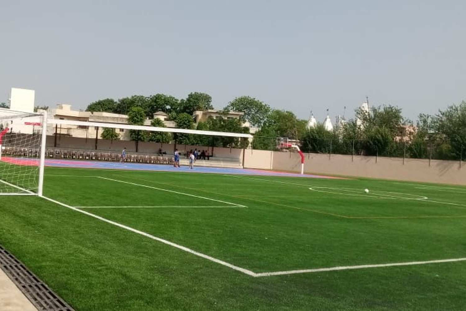Outdoor football turf ground in Agartala with artificial green grass, white boundary markings and goal posts