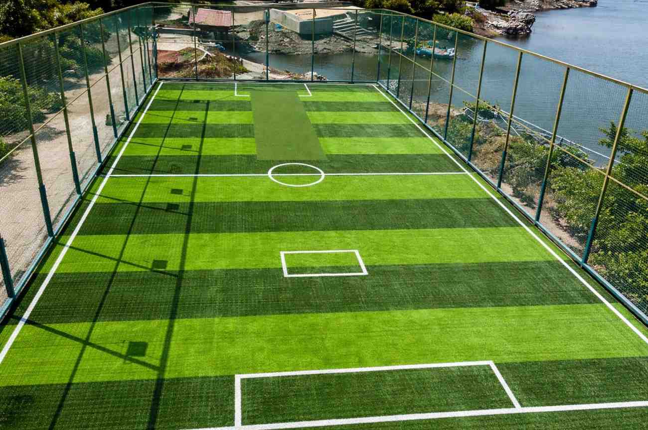 Modern football turf ground in Shillong with synthetic green grass, white corner markings and goal posts