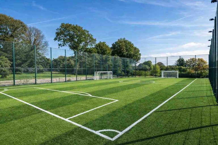 Outdoor football turf ground in Silchar with artificial green grass, white boundary markings and goal posts